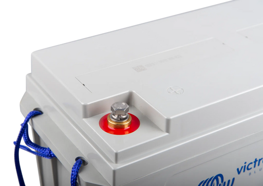 Close-up of a battery with a red terminal and blue cable, branded 'Victor'.